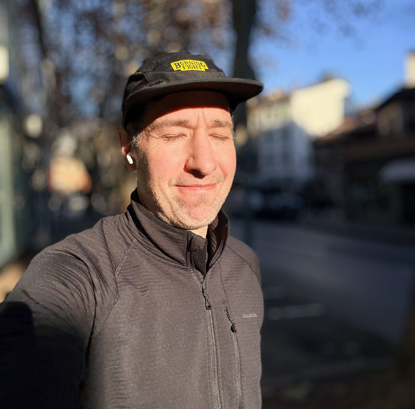 The author in running gear staring into the sun smiling