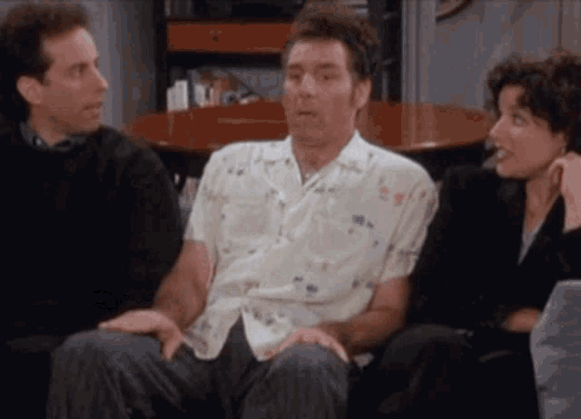a man sits on a couch with two other people a man sits on a couch with two other people