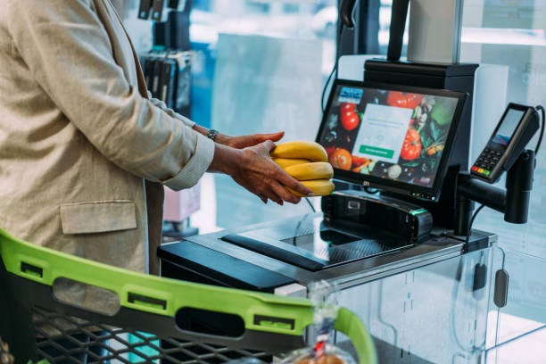 Woman using self service checkout. Shot of a woman scans products at the self-service checkout in the grocery supermarket shop. Woman buyer in a supermarket pays for goods at a self-service checkout. self check out stock pictures, royalty-free photos & images