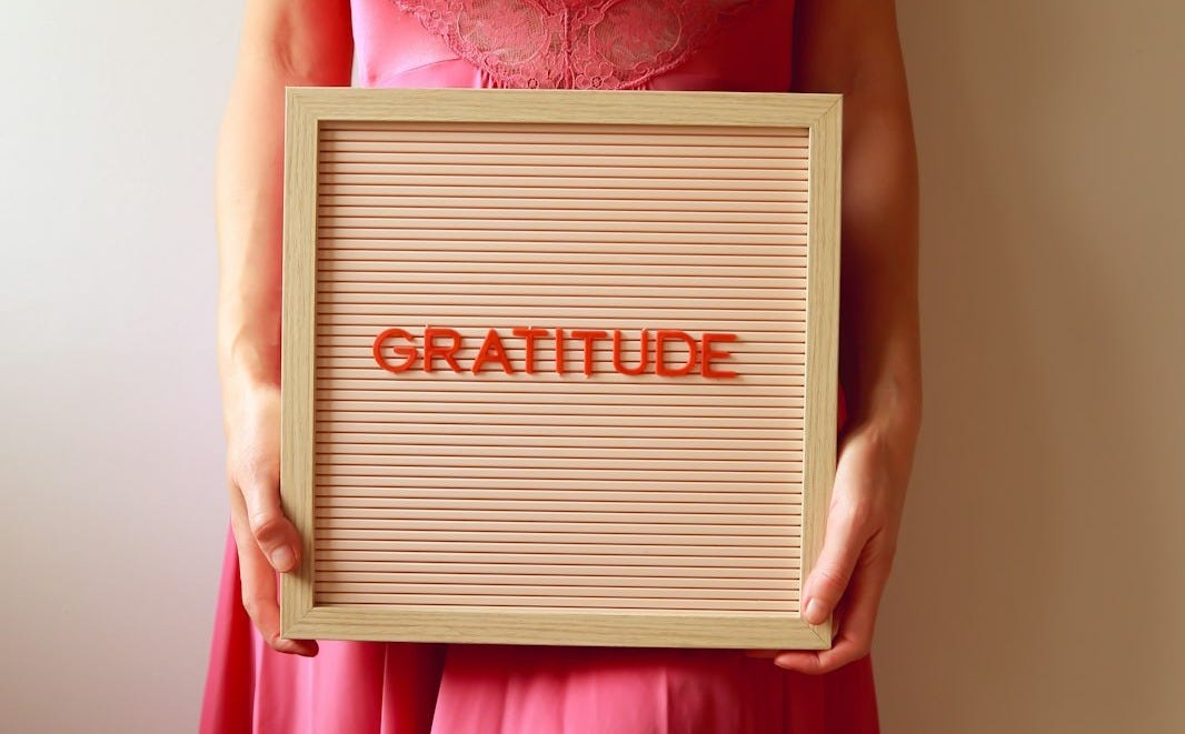 Woman holding a sign that says "gratitude".
