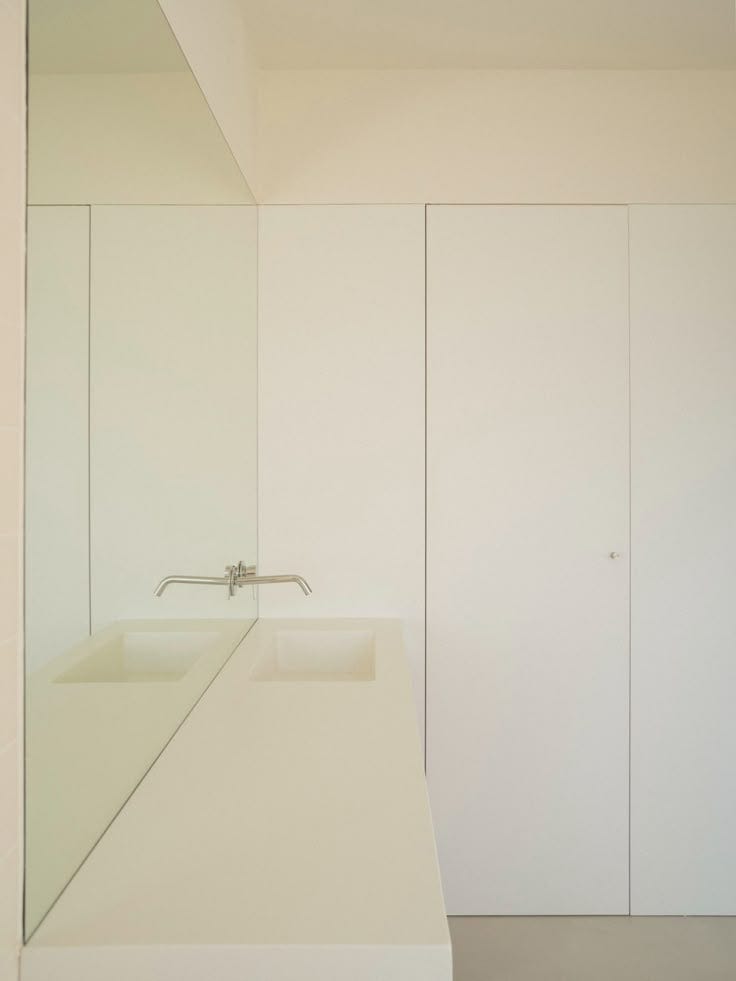 This may contain: an empty bathroom with white walls and cabinets