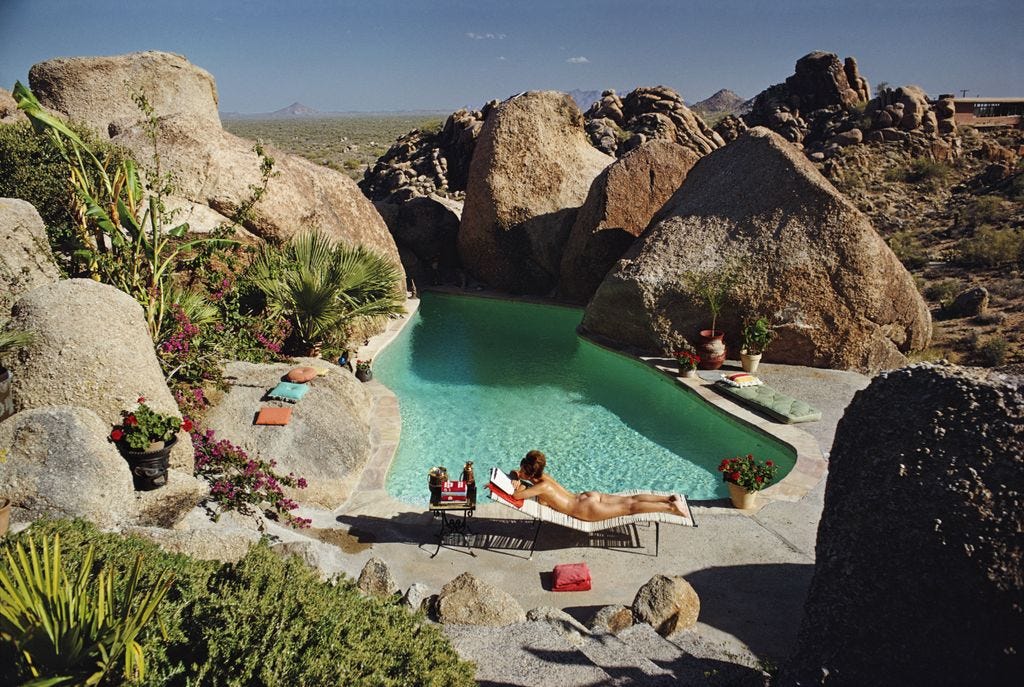 Una mujer tomando el sol desnuda en la piscina de Tom Darlington en Carefree Arizona slim aarons