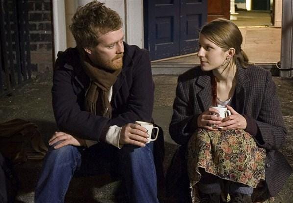 Still from Once showing Glen Hansard and Marketa Irglova sitting on a stoop at night drinking coffee/tea