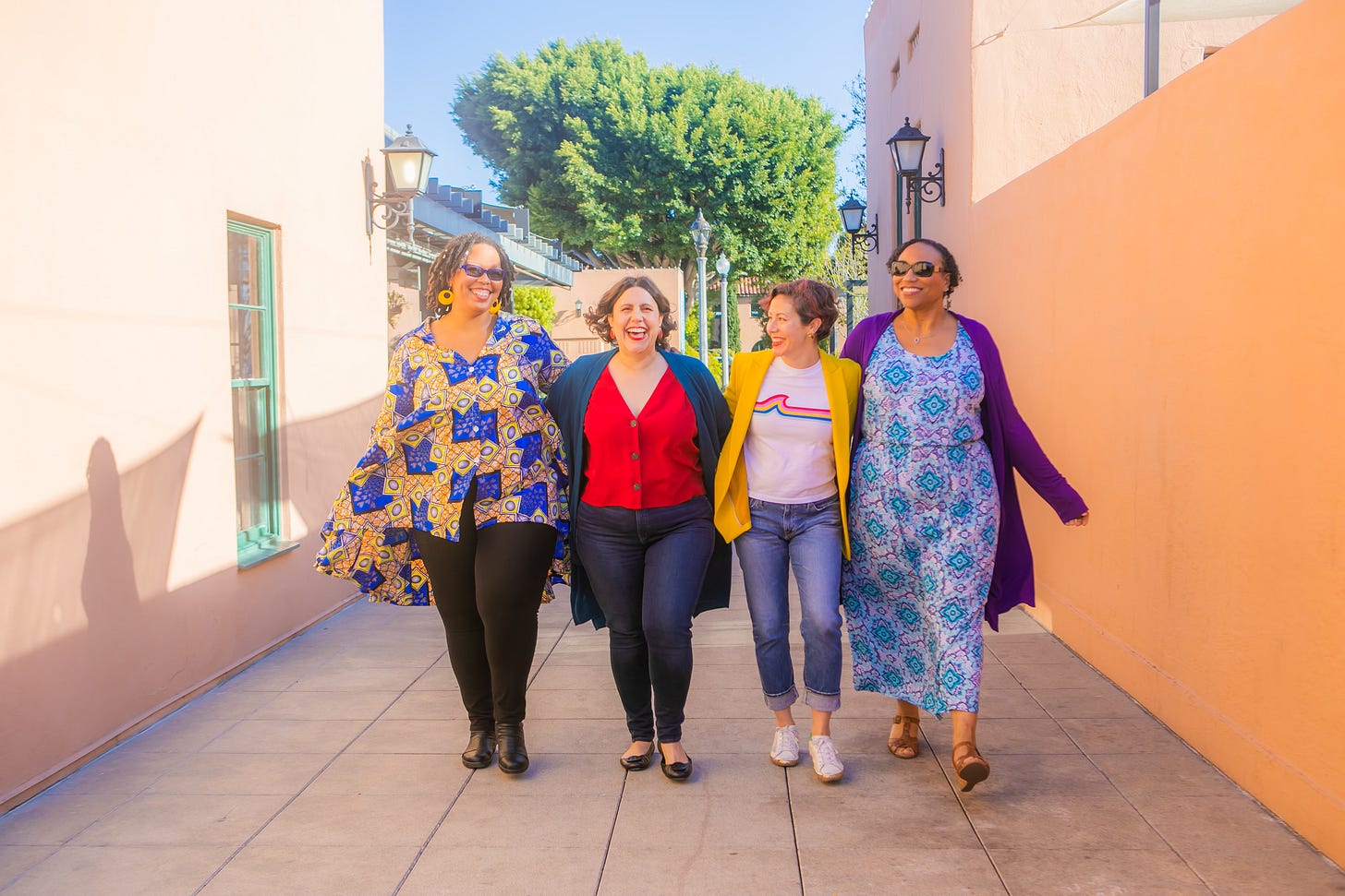 Lauren and three friends all walk down the street together in bright clothes.