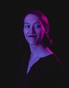 A headshot of cellist Fiona Robson, with magenta and purple highlights