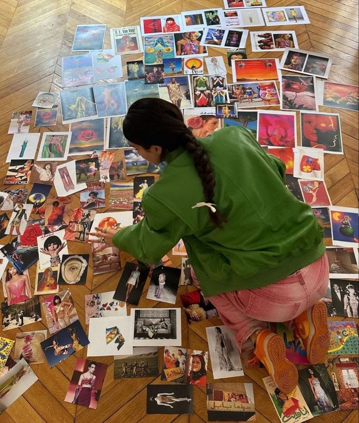 This may contain: a woman sitting on the floor surrounded by pictures