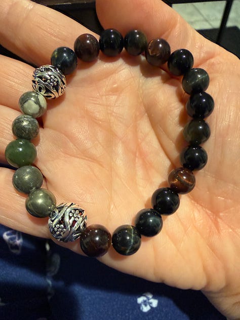 A variety of bead bracelets in various colors and pink mala beads and tiger's eye mala beads