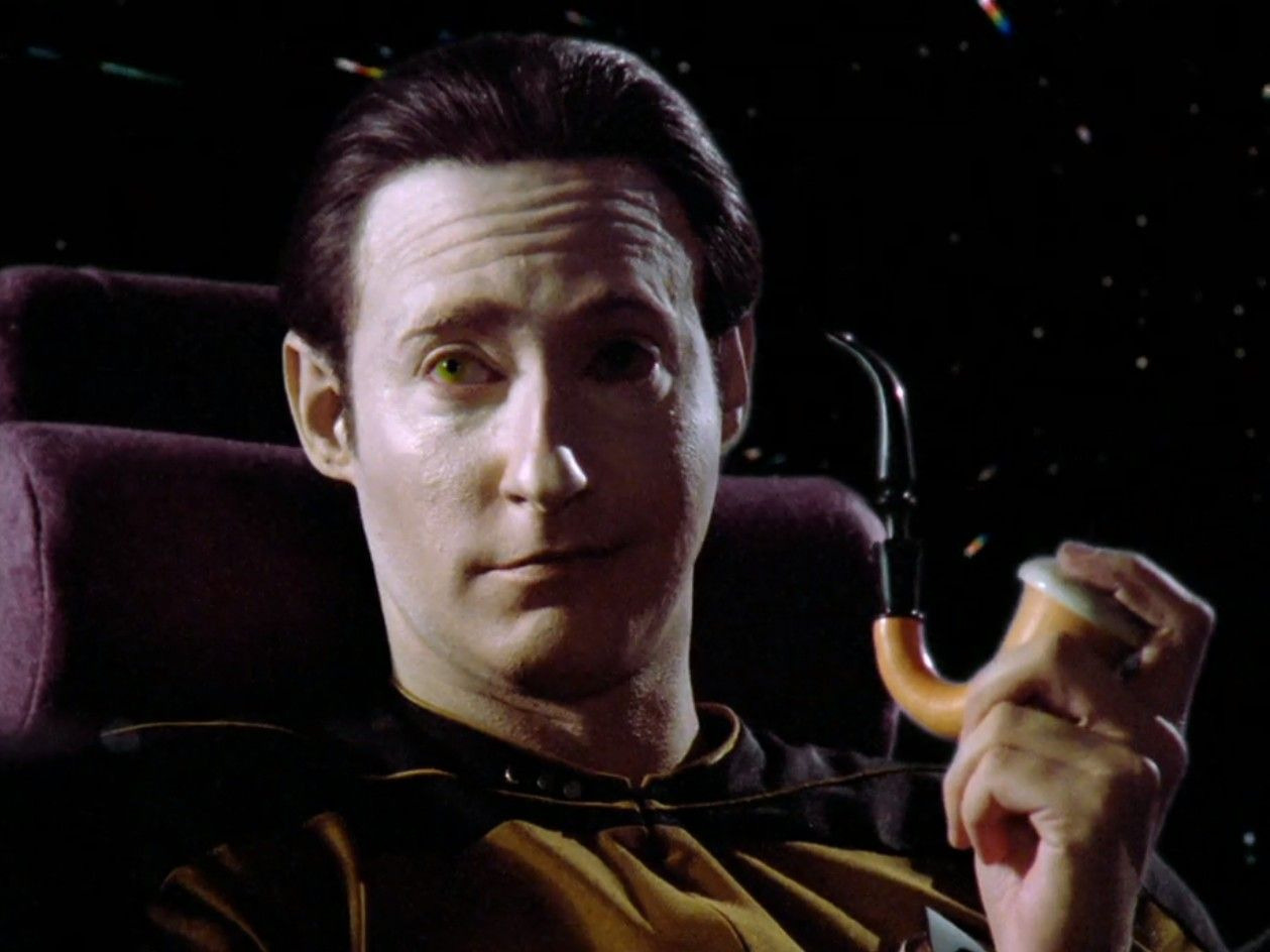Star Trek TNG character Data holding a pipe and smirking