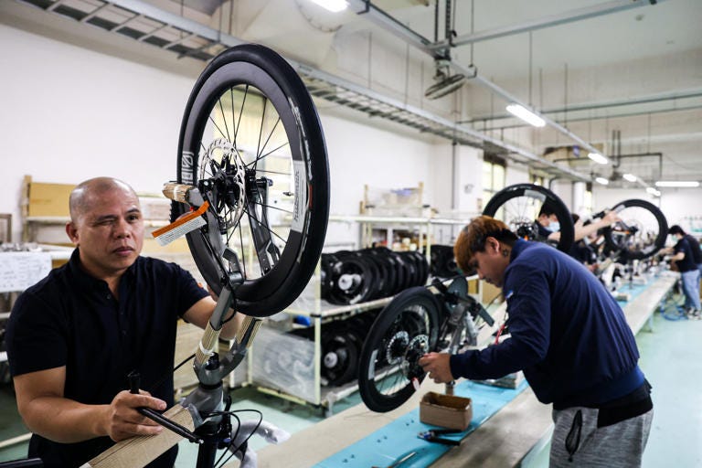 In this picture taken on April 30, 2025, workers check the quality of fold-up bicycles at a factory of Pacific Cycles in Taoyuan. US president Donald Trump's initial 32 percent tariff on Taiwan stunned the island's bicycle manufacturers, who were racing to meet orders ahead of the northern summer before the new toll was announced.