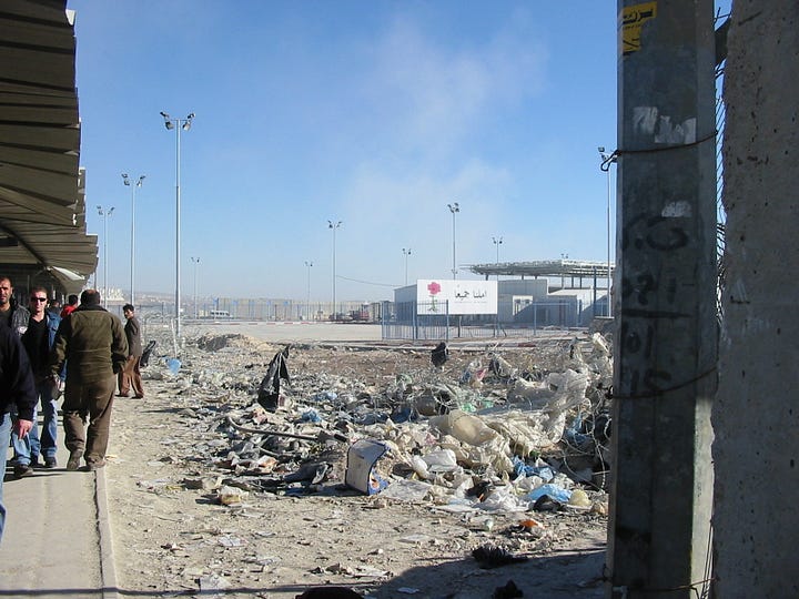 Left: A crowd of Palestinians — men and women, some in headscarves — queue under a corrugated metal canopy at Qalandia checkpoint. A chain-link fence runs along the left. Concrete barriers channel the line forward. An Israeli flag is visible in the middle distance. Additional waiting crowds stretch toward the checkpoint inspection point in the background. Right: A view toward the Qalandia checkpoint gate in December 2005. Rubble and debris fill the foreground. A security gate and white terminal building are visible in the background, with a billboard bearing a red rose and Arabic text reading "The Hope for All of Us." Several men walk along a concrete path to the left. Floodlights on tall poles frame the scene under a clear blue sky.