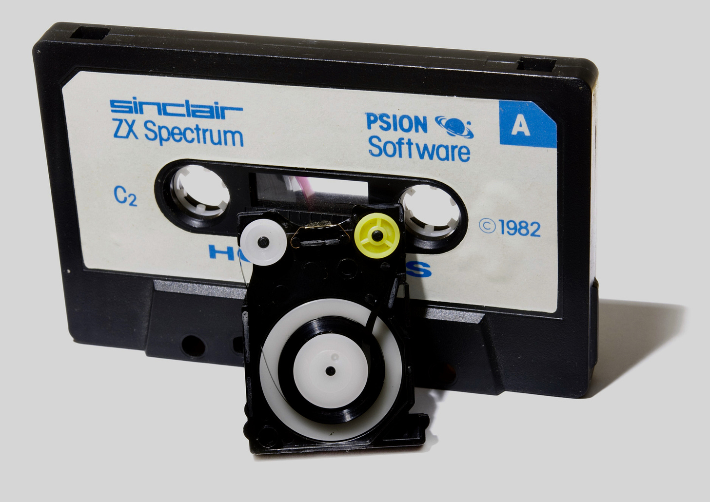 An audio cassette and the inside of a Sinclair Microdrive. 