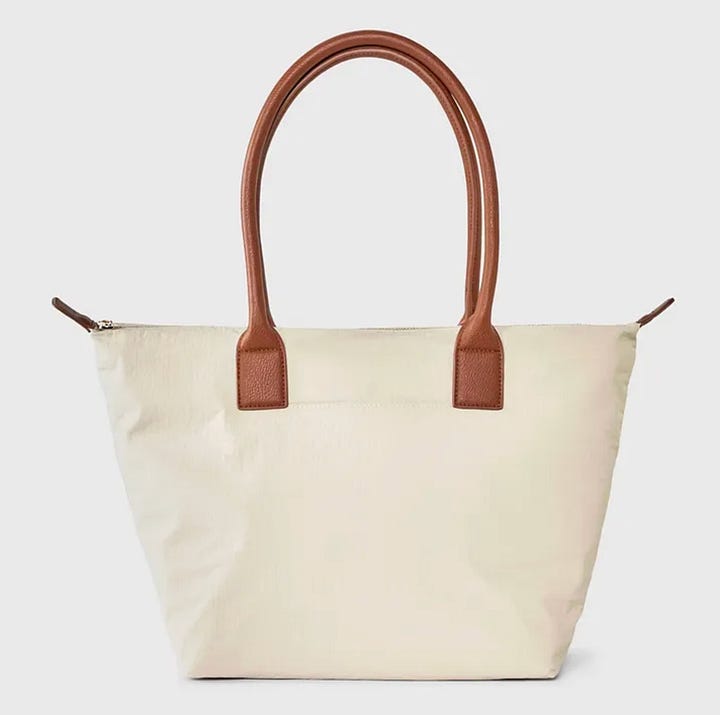 A purple floral dress, a woman wearing a white shirt, grey sneakers, and a white tote bag.