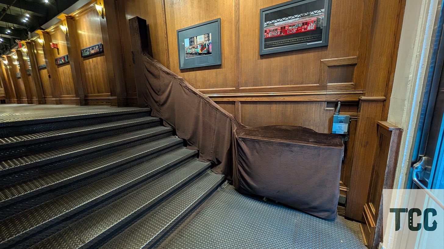 A wheelchair lift on the stairs at the entrance of the building.