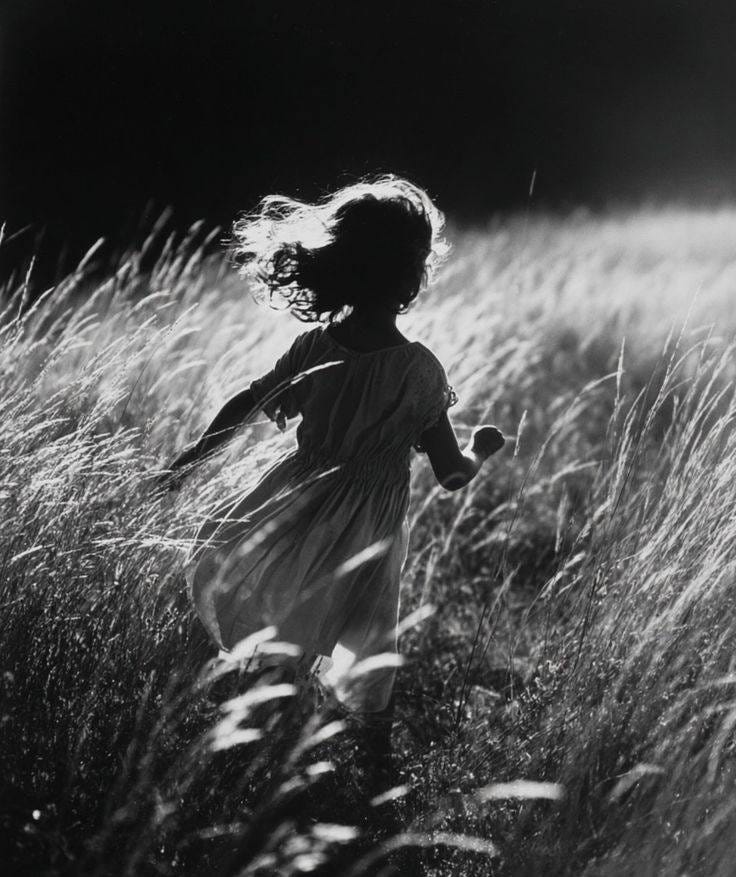 May be a black-and-white image of child and grass