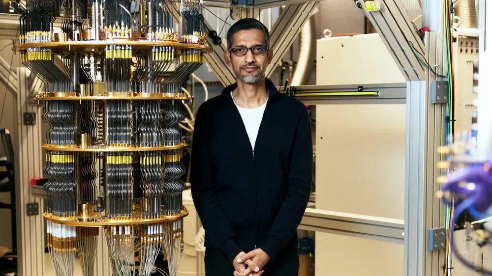 a picture of Sundar Pichai standing next to a quantum computer