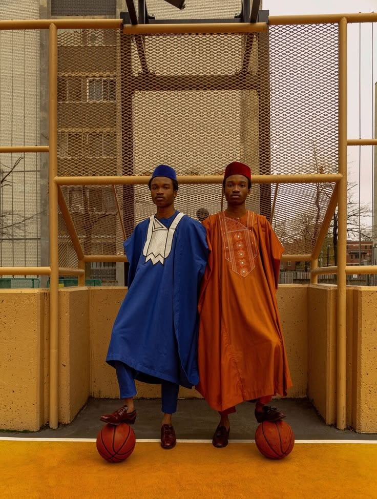 This may contain: two young men standing next to each other with basketballs
