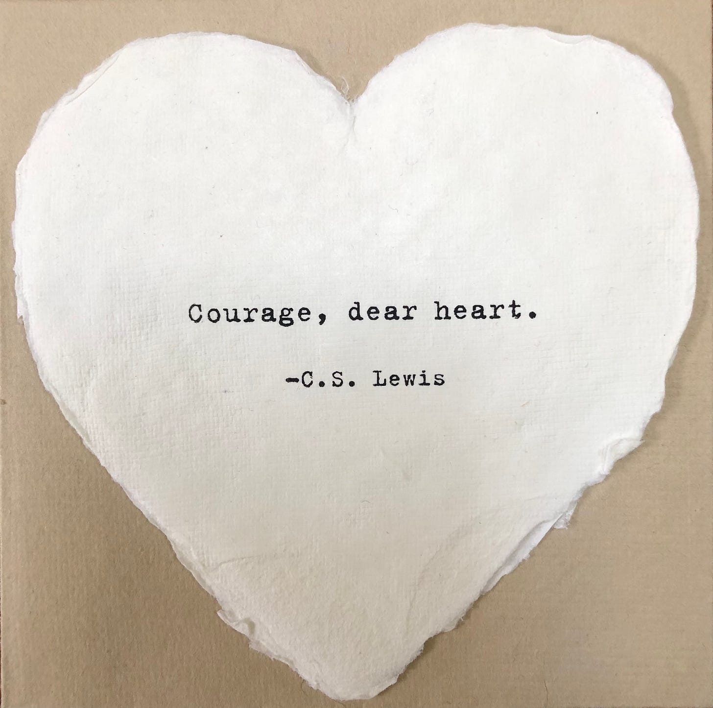 A while heart-shaped greeting card with the words “Courage, dear heart. —C.S. Lewis”