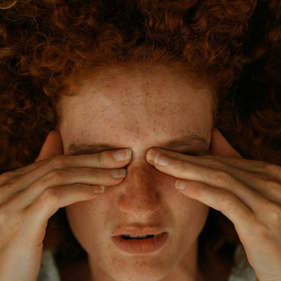 a woman with red hair covering her eyes a woman with red hair covering her eyes