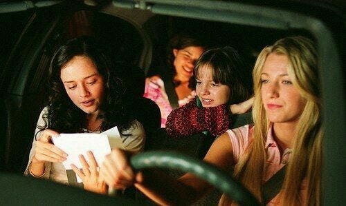This may contain: three women are sitting in the back seat of a car and one woman is holding a piece of paper