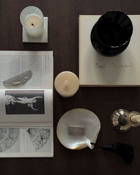 This may contain: an assortment of items on a table including candles and books