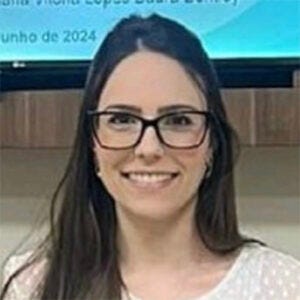 Mulher de cabelos castanhos longos e camisa branca. Ela sorri para a foto. Mulher de cabelos castanhos longos e camisa branca. Ela sorri para a foto.