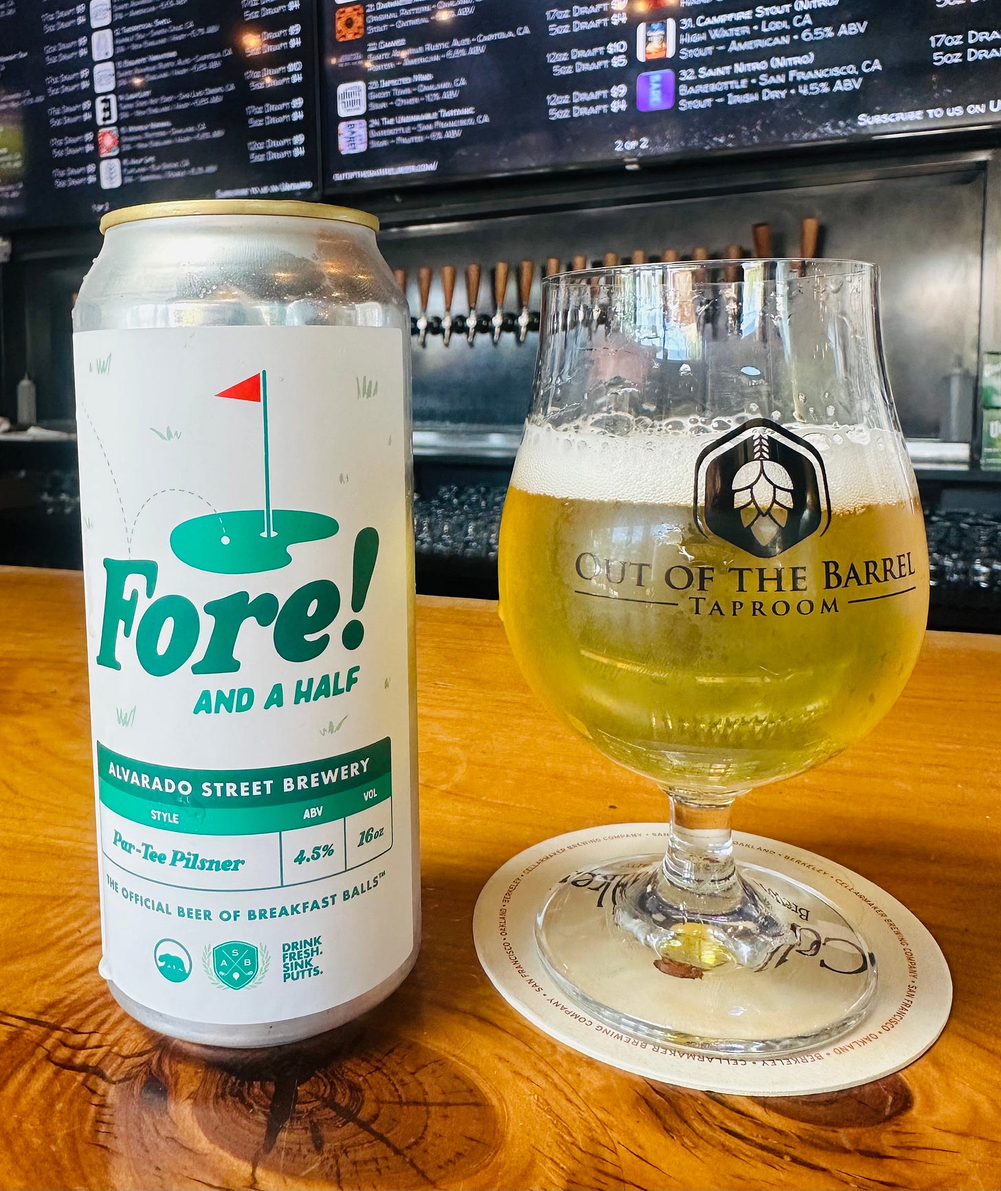 a can of "Fore" Pilsner beer from Alavarado Street set next to a glass on a bar