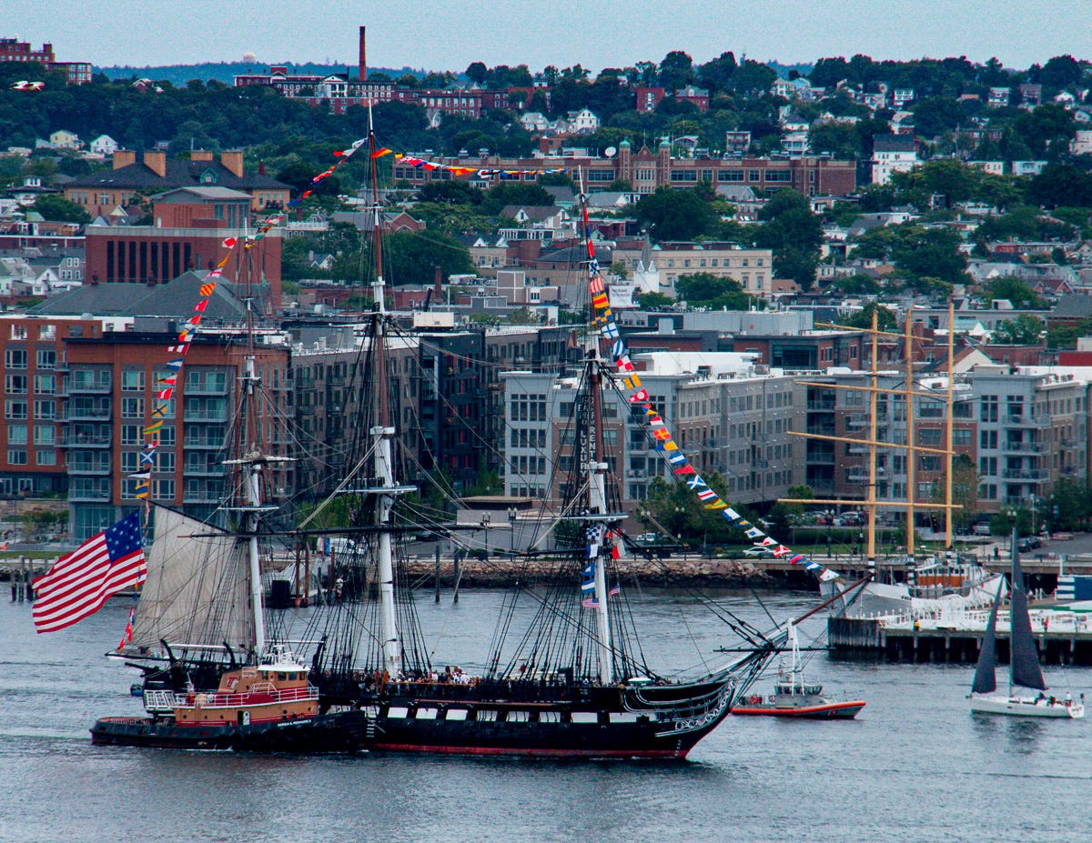 Photograph shot from 14th Floor Balcony of USS Constitution Sailing Ship in Boston HArbor with Escorts and Tug Boats FAcing East Photograph shot from 14th Floor Balcony of USS Constitution Sailing Ship in Boston HArbor with Escorts and Tug Boats FAcing East