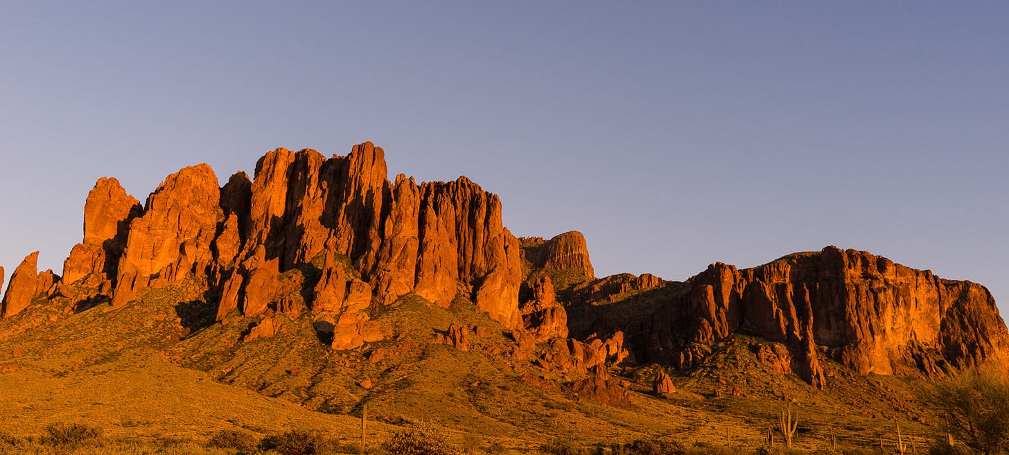 A mountain with spire peaks at sunset.