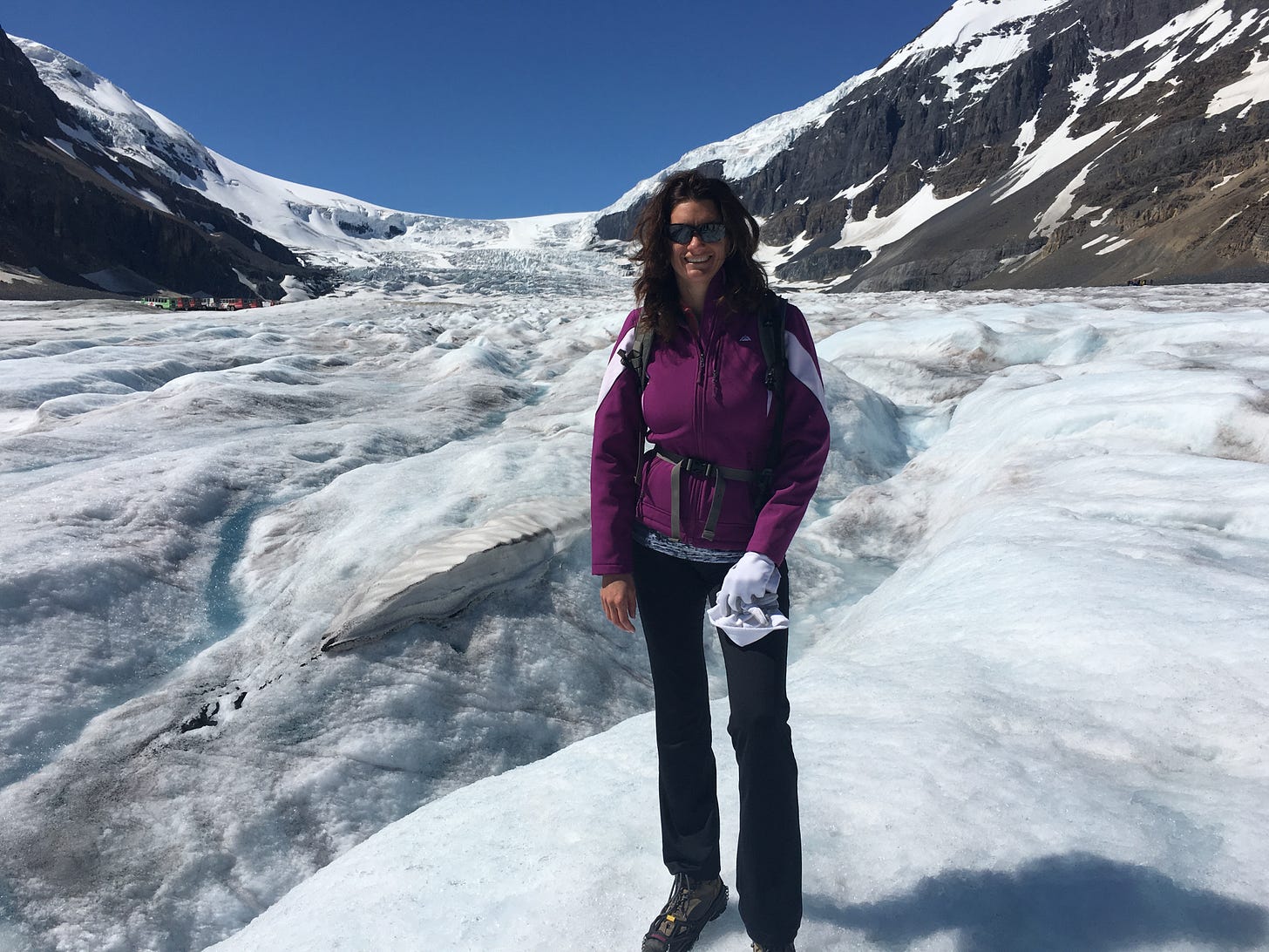 Tourists walking on Athabasca Glacier ice with crampons during Columbia Icefield tour, popular Banff-Jasper activity