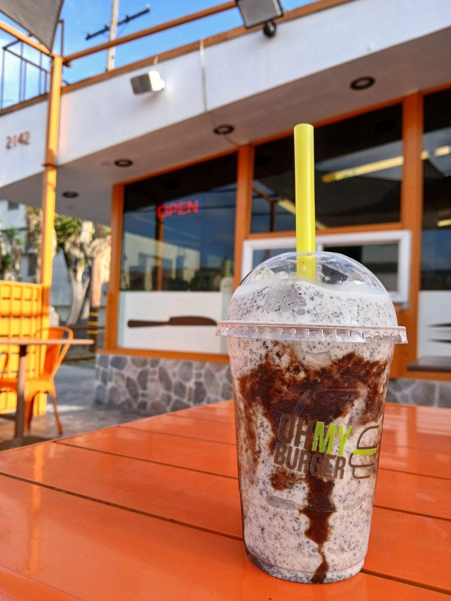 An Oreo milkshake stands on a table in front of the bright orange and yellow patio outside of the Oh My Burger restaurant Thursday, April 24. The restaurant started in 2011 and sells milkshakes costing between $7.50 and $9. (Tina Talley | The Union)
