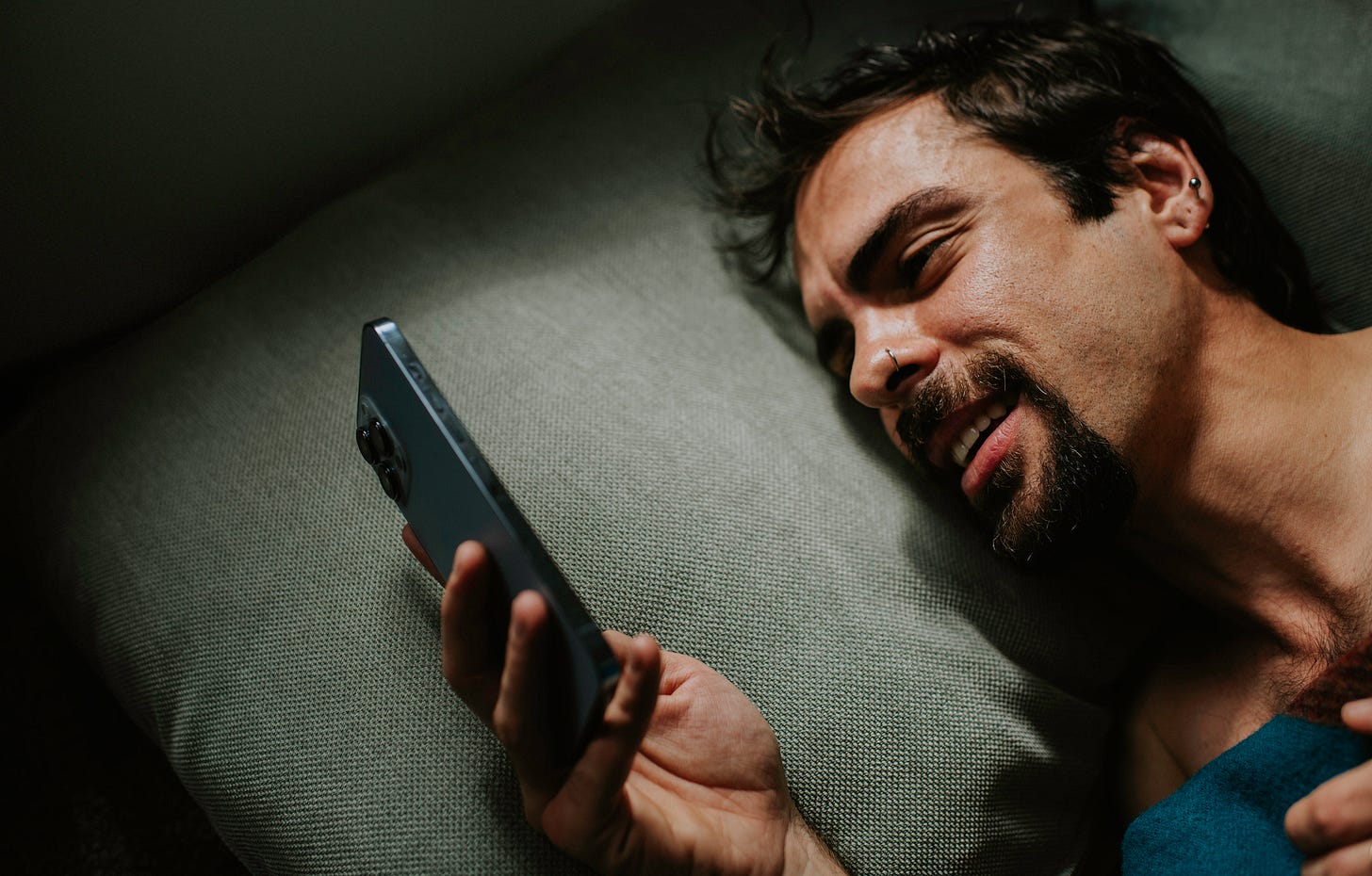 Man looking at his phone at night in bed Man looking at his phone at night in bed