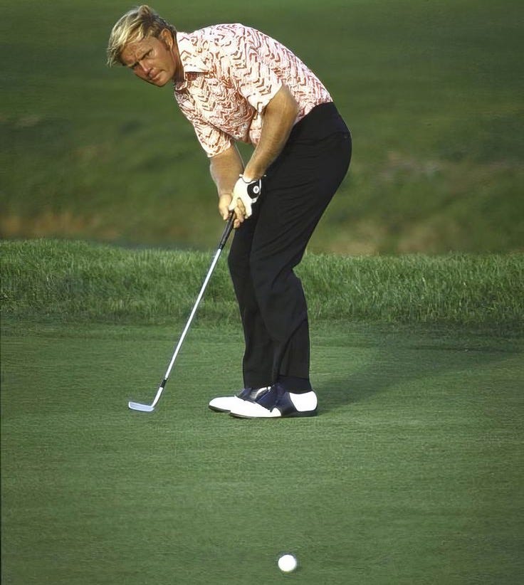 This may contain: an older man is playing golf on the green with his foot in the air, This may contain: an older man is playing golf on the green with his foot in the air,
