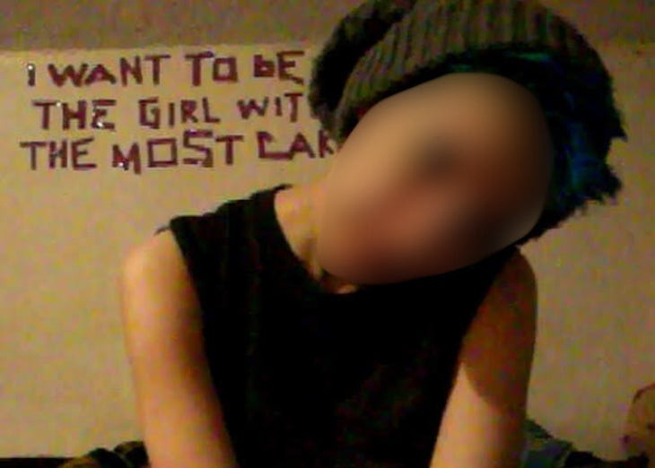 Me in my attic room with the words "I WANT TO BE THE GIRL WITH THE MOST CAKE" spelled out behind me. I have short blue hair and I'm wearing a beanie. Me in my attic room with the words "I WANT TO BE THE GIRL WITH THE MOST CAKE" spelled out behind me. I have short blue hair and I'm wearing a beanie.