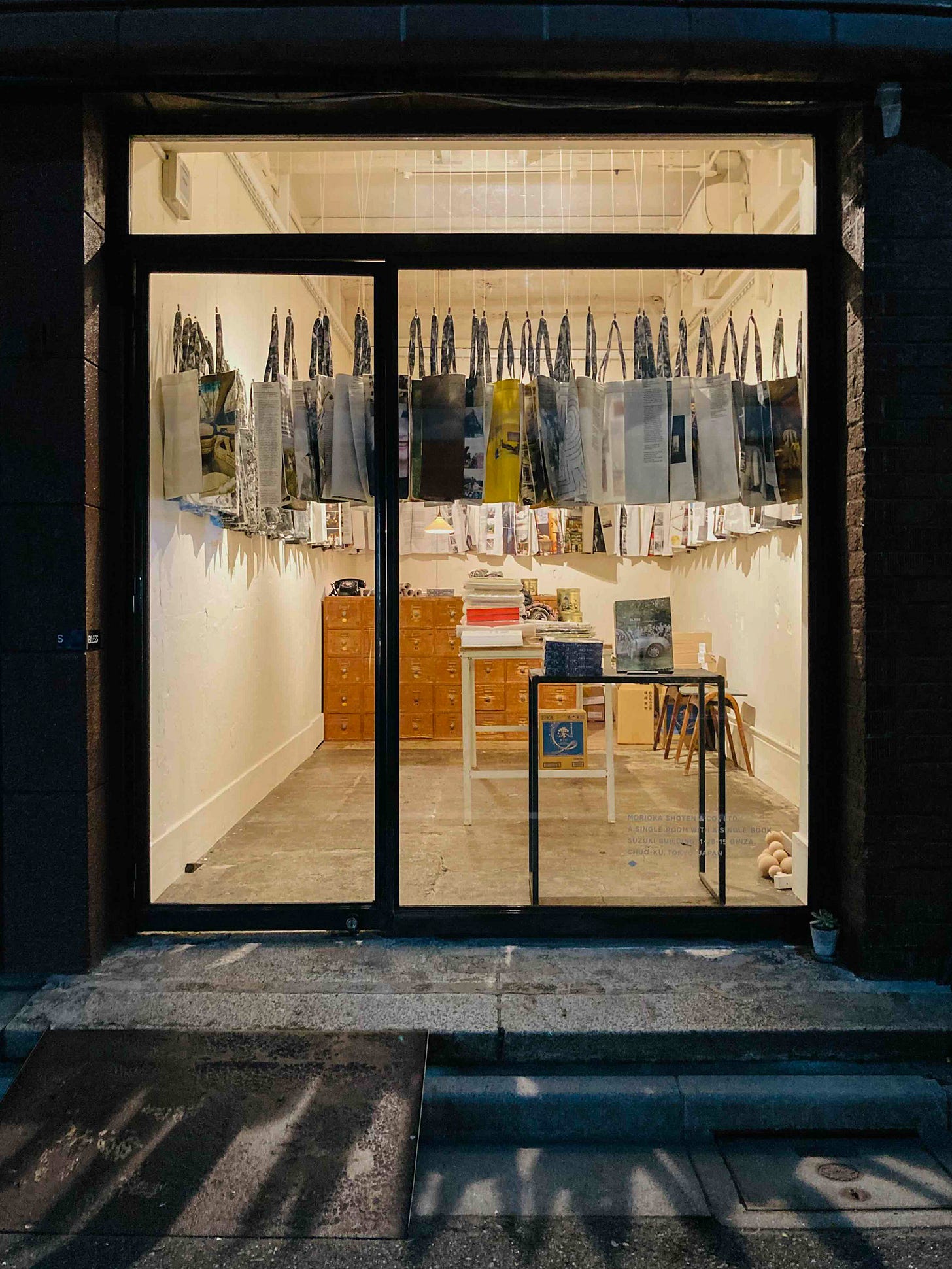 exterior of morioka shoten bookstore filled with hanging tote bags exterior of morioka shoten bookstore filled with hanging tote bags