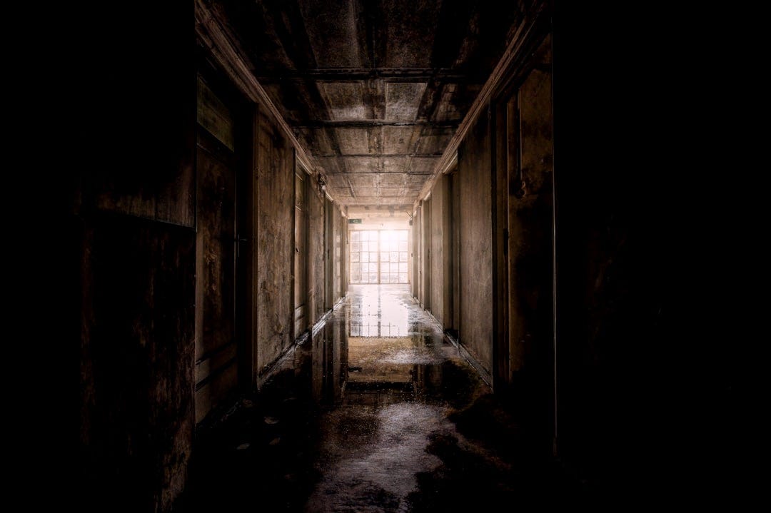 a dark hallway with light coming through the window