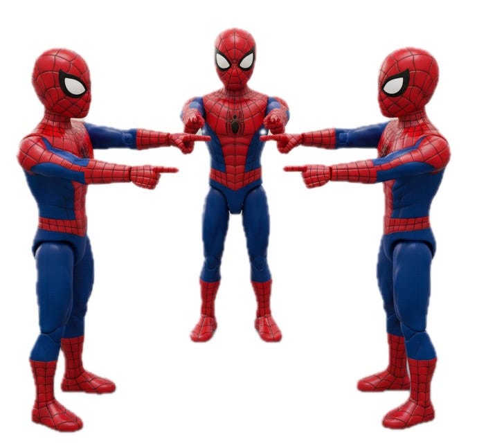 Three identical, articulated action figures in red-and-blue suits stand in a triangular formation against a stark white background. Each figure is oriented inward toward the center of the group, with both arms fully extended. Every figure points one hand at the figure to their left and the other hand at the figure to their right, creating a continuous loop of mutual recognition. The characters feature large, stylized white eyes on their masks and a grid-like pattern across the red portions of their costumes, emphasizing the symmetry and identical nature of the three figures.