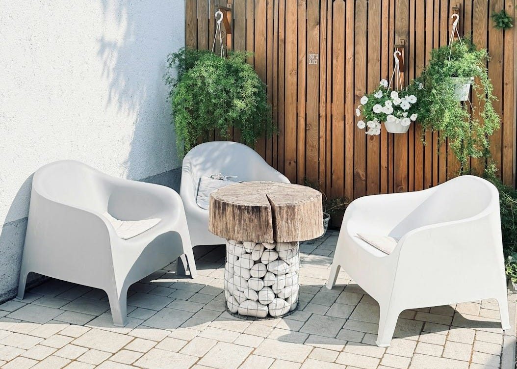 Cozy outdoor patio with white chairs and a rustic table. Cozy outdoor patio with white chairs and a rustic table.