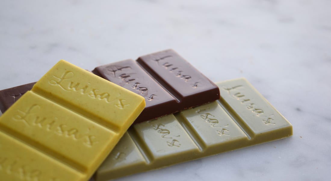 Three chocolate bars - one yellow, one brown, and one green - on top of a marble table Three chocolate bars - one yellow, one brown, and one green - on top of a marble table