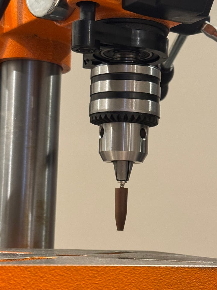 A photograph of a Wen drill press with rubber Cratex abrasive bit as used for creating perlage as in luxury watchmaking.