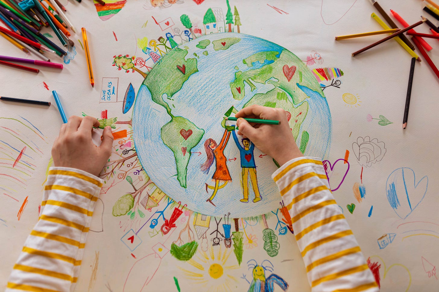 High angle view of unrecognizable boy draw the planet Earth with people High angle view of unrecognizable boy draw the planet Earth with people