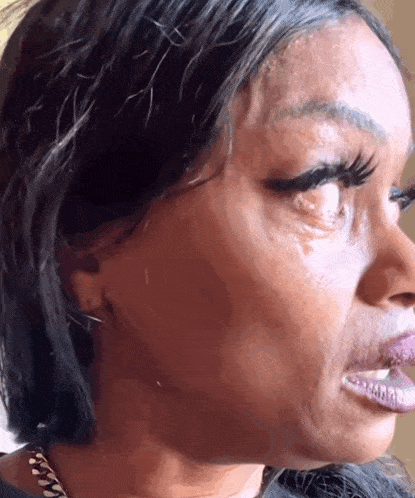 a close up of a woman 's face with a tear in her eye a close up of a woman 's face with a tear in her eye
