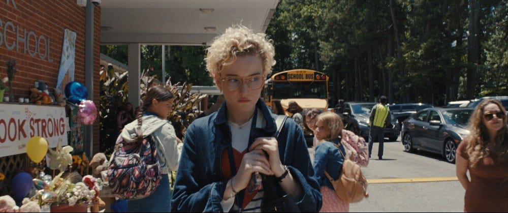 Julia Garner in Weapons walking into school from the parking lot with a backpack