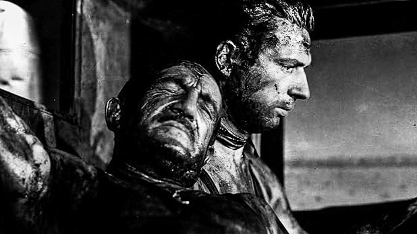 Yves Montand and Charles Vanel, drenched in sweat and oil, inside a nitroglycerin-laden truck in The Wages of Fear (1953). Yves Montand and Charles Vanel, drenched in sweat and oil, inside a nitroglycerin-laden truck in The Wages of Fear (1953).
