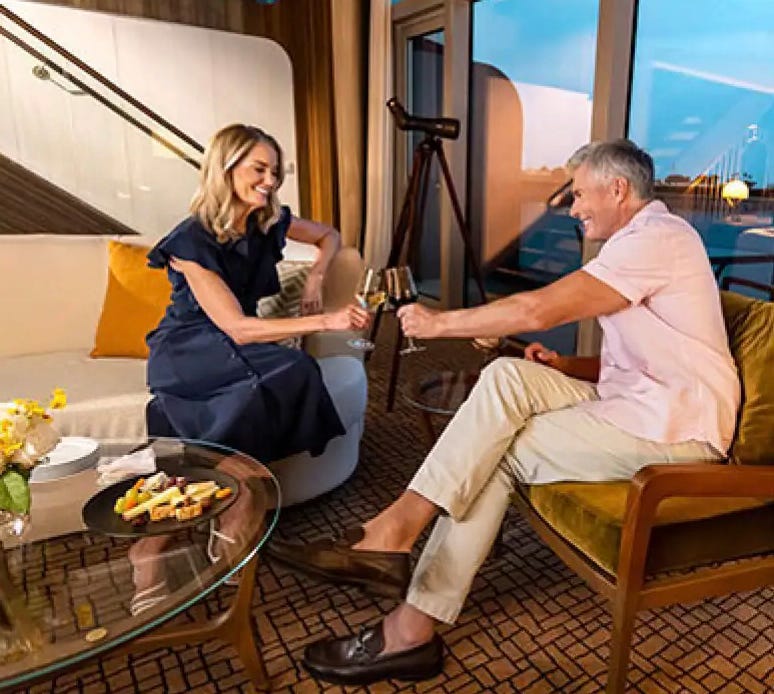 Photograph of a man and a woman seated on board a cruise ship drinking wine