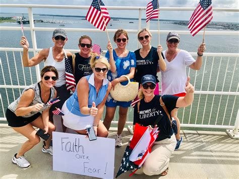 A group of Moms for Liberty waving American flags and smiling