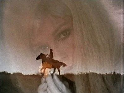 This may contain: a woman holding a toy horse in front of her face