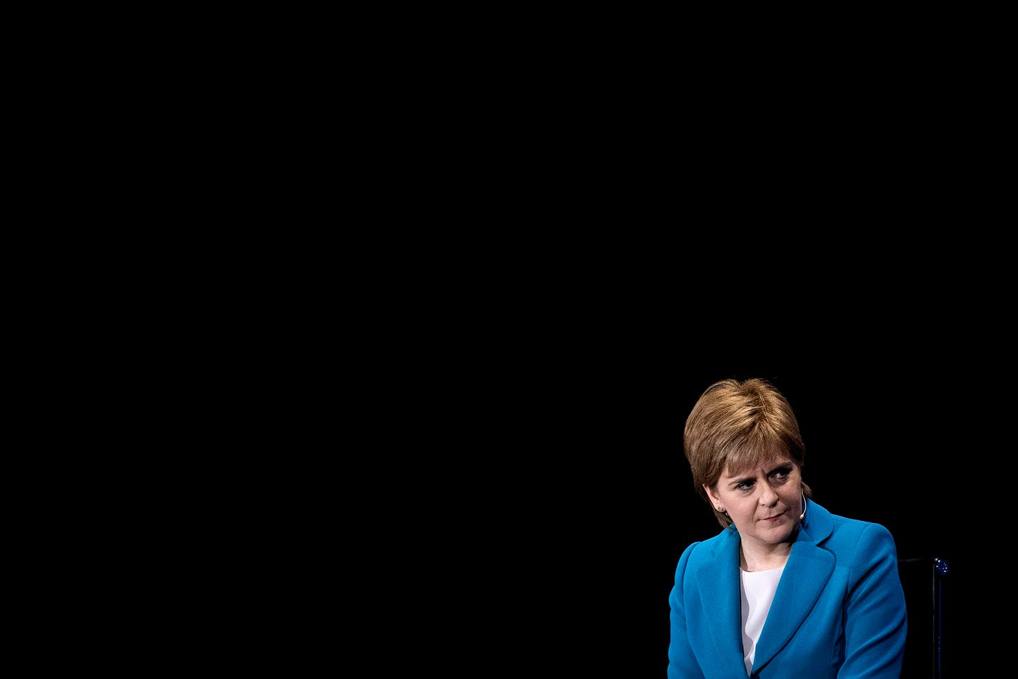 Nicola Sturgeon in blue on black background