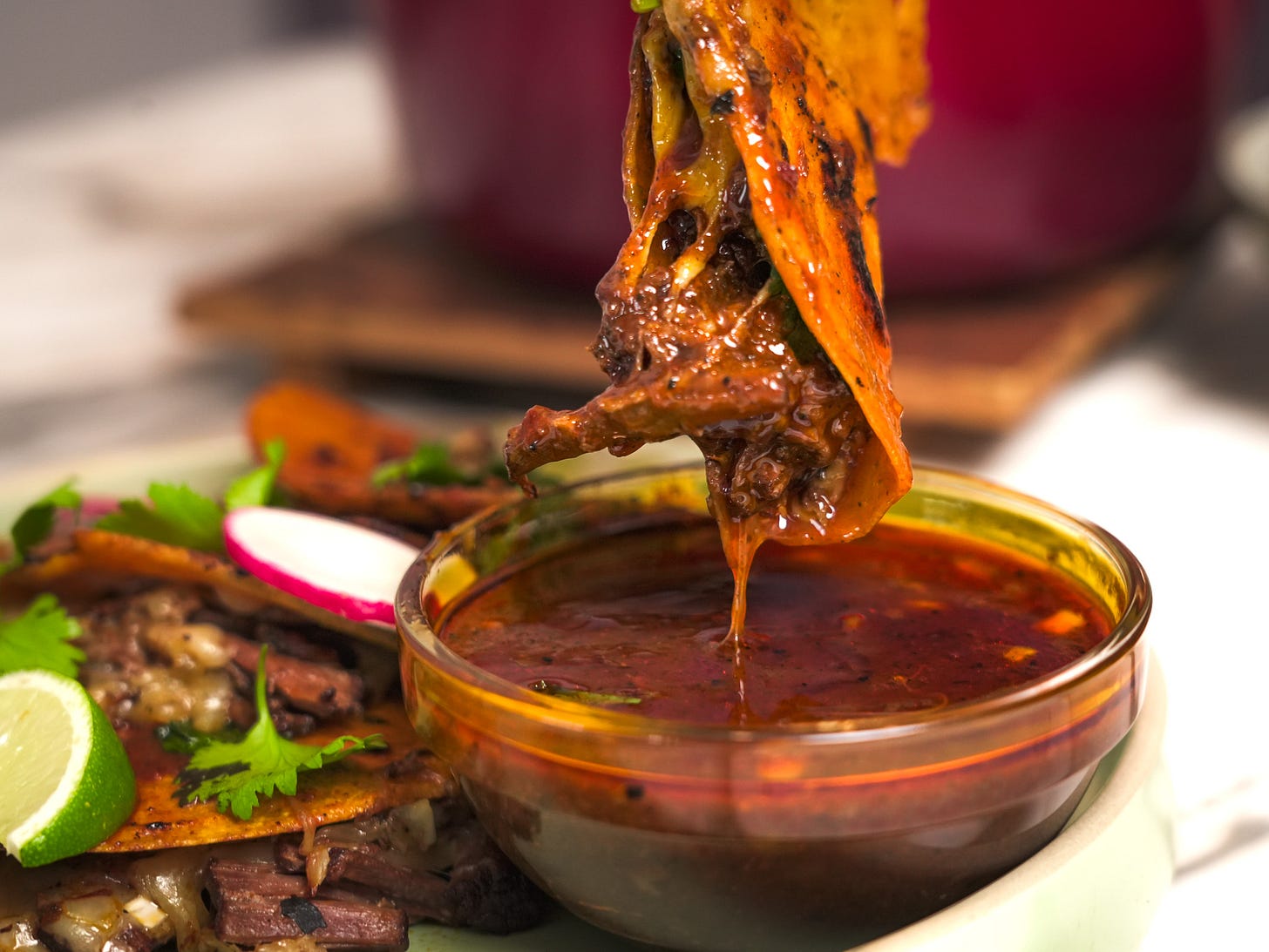 birria tacos dipping in sauce
