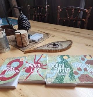 Jeff Nania's four Northern Lakes Mysteries on a cabin table.
