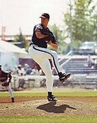 A baseball player throwing a ball

Description automatically generated